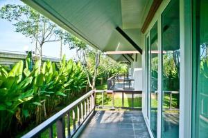 eine Veranda eines Hauses mit grünen Pflanzen in der Unterkunft Baan Chong Fa Resort in Khao Lak