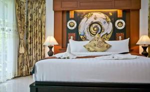a bedroom with a large bed with a large headboard at Baan Chong Fa Resort in Khao Lak