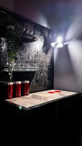 a table with red drums and a light on a wall at BDSM Red Room Apartment in Łódź