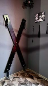 una cruz de madera en la pared de una habitación en BDSM Red Room Apartment, en Łódź