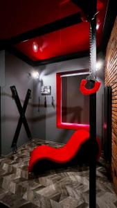 una silla roja en una habitación con techo rojo en BDSM Red Room Apartment, en Łódź