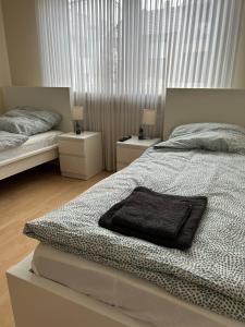 a white bedroom with two beds and two night stands at Gästehaus in Titz 