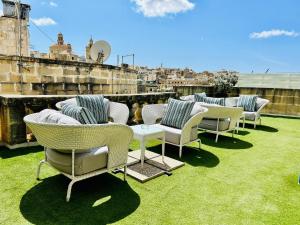 a row of chairs and tables on a roof at Casa Birmula Boutique Hotel in Cospicua