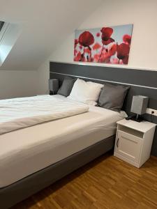 a bedroom with a large bed with a lamp on a night stand at New Age Boardinghaus Bad Wimpfen in Bad Wimpfen