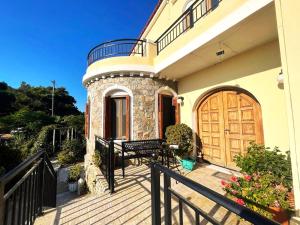 a house with a wooden door and a bench on a porch at Litani House in Raches