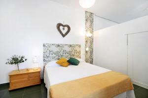 - une chambre avec un lit au cœur du mur dans l'établissement Loft con encanto, à Chiclana de la Frontera