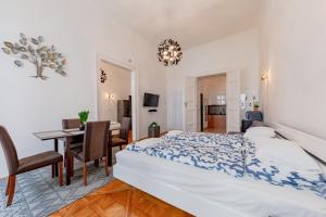 een slaapkamer met een bed en een eetkamer bij La Fortezza Panzió in Boedapest