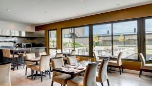 Auberge Du Vin, a Tribute Portfolio Hotel في توبونغاتو: مطعم بطاولات وكراسي ونوافذ
