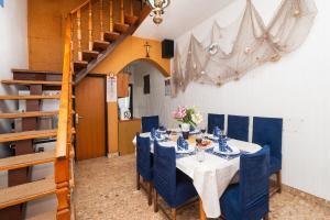 a dining room with a table with blue chairs and a staircase at House Brunac with parking in Vodice +61 photos