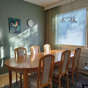 - une table à manger avec des chaises et une table en bois dans l'établissement Scandinavian taiteilijan 3h huoneisto, à Lahti
