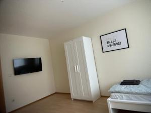 a bedroom with a tv and a door with a sign at Gästehaus in Titz 