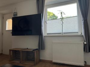 uma sala de estar com uma televisão, uma mesa e uma janela em Appartement Anna em Niederau
