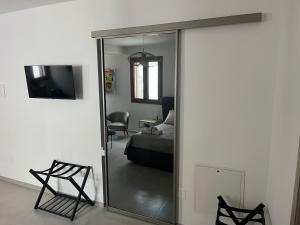 a mirror in a room with a bed and a chair at Le dimore di Bobo in Bernalda