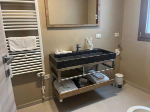 een badkamer met een wastafel, een spiegel en handdoeken bij Le dimore di Bobo in Bernalda