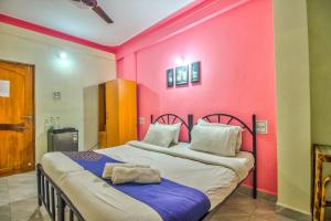 two beds in a room with a pink wall at Downtown in Calangute