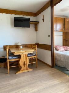 een kamer met een houten tafel en een bed bij Nid aux Menuires in Les Menuires