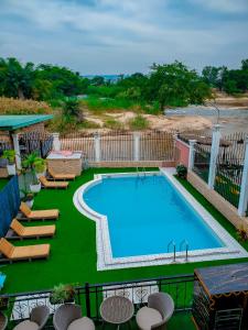 une grande piscine avec des chaises longues dans l'établissement RIVER APPARTS, à Brazzaville