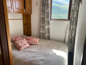 een klein bed in een kamer met een raam bij Nid aux Menuires in Les Menuires +4 foto's