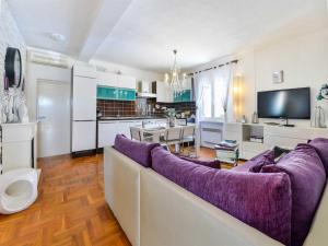 sala de estar con sofá púrpura y cocina en Seaview Holiday Home GATSBY, en Petrčane