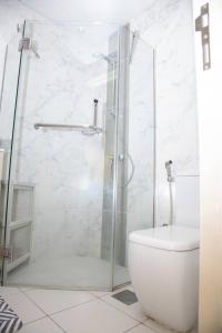 a bathroom with a toilet and a glass shower at Tamm - Luxe Condo With Balcony and Incredible City Views in Dubai