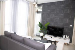 ein Wohnzimmer mit einem Sofa und einem TV in der Unterkunft Tamm - Luxe Condo With Balcony and Incredible City Views in Dubai