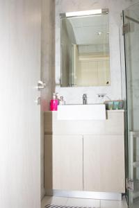 y baño con lavabo y espejo. en Tamm - Luxe Condo With Balcony and Incredible City Views en Dubái