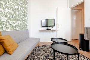 a living room with a couch and two tables at Studio Estelle's with Private Parking in Zandvoort