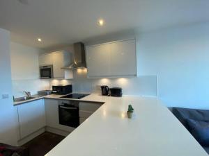 a kitchen with white cabinets and a white counter top at Cozy 1 BR Flat in Sutton NH15 in Sutton