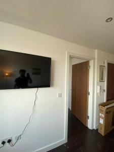 En tv och/eller ett underhållningssystem på Cozy 1 BR Flat in Sutton NH15