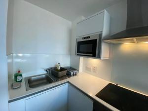 Una cocina o zona de cocina en Cozy 1 BR Flat in Sutton NH15