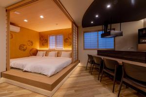 ein Schlafzimmer mit einem großen Bett und einer Bar in der Unterkunft 【Oyado街】宿泊者限定！貸切クルーザー・SUPツアー　別荘感覚で新築一軒家貸切ハウステンボス近く in Hayaki