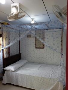a bedroom with a bed with a mosquito net at 152-Abhaya Place Homestay in Talalla