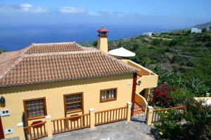 a yellow house with a lighthouse on a hill at Los Nacientes: Marcos in Los Sauces