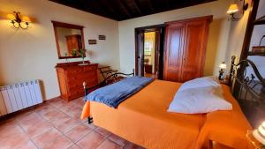 a bedroom with an orange bed and a wooden dresser at Los Nacientes: Marcos in Los Sauces