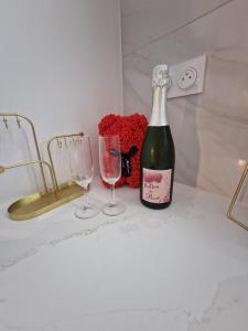 Una botella de champán y dos copas en un mostrador. en Maison SPA DISNEY, en Lagny