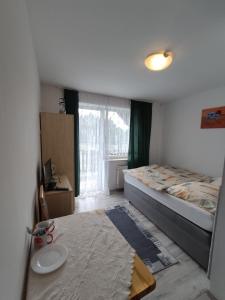 a bedroom with a bed and a table and a window at Pokoje Gościnne U Dany in Jarosławiec