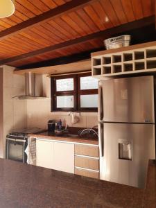 una cocina con nevera de acero inoxidable. en Apartamento com pátio e anexo exclusivo en Torres