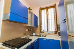a small kitchen with blue cabinets and a sink at La casetta di Lula in Trapani