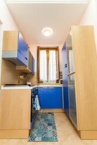 a kitchen with blue cabinets and a refrigerator at La casetta di Lula in Trapani
