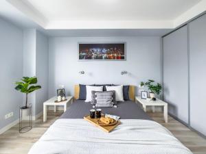 - une chambre avec un grand lit et un plateau dans l'établissement Apartament z widokiem na panoramę miasta, à Cracovie