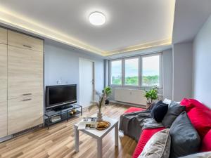 ein Wohnzimmer mit einem Sofa und einem Flachbild-TV in der Unterkunft Apartament z widokiem na panoramę miasta in Krakau