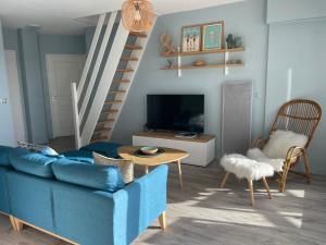 アルゾンにあるREF 048 - Appartement entièrement rénové pour six personnes vue mer et port Crouesty ARZONの青いソファとテーブルのあるリビングルーム