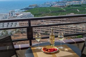 a table with two glasses of wine and a bowl of fruit at Club Paraiso 1306 in Playa Paraiso