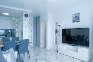 uma sala de estar com uma grande televisão e uma mesa em Club Paraiso 1306 em Playa Paraiso