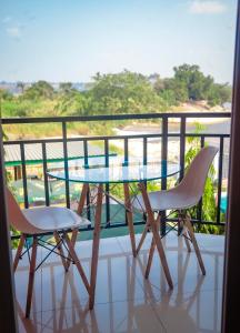 d'une table en verre et de deux chaises sur un balcon. dans l'établissement RIVER APPARTS, à Brazzaville
