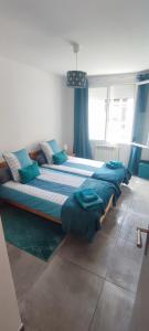 - un grand lit dans une chambre dotée de rideaux bleus dans l'établissement Maison de village avec une pièce de vie lumineuse, à Saint-Paul-de-Fenouillet