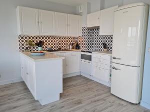 アルゾンにあるREF 048 - Appartement entièrement rénové pour six personnes vue mer et port Crouesty ARZONの白いキッチン(白いキャビネット、冷蔵庫付) +6枚の写真