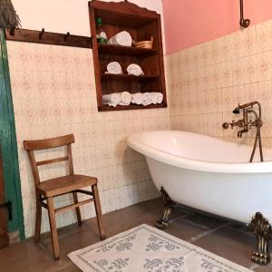 a bathroom with a tub and a chair in it at Holiday house Luin in Komen