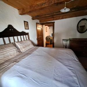 ein Schlafzimmer mit einem großen weißen Bett in einem Zimmer in der Unterkunft Holiday house Luin in Komen