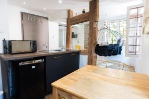 a kitchen with black cabinets and a wooden table at Appartement de la noblesse - designed by C.M in Sélestat